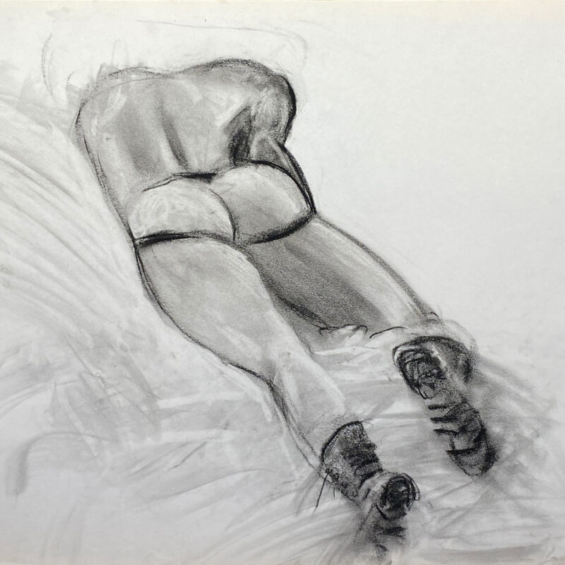 charcoal drawing of male model laying in jocks and boots